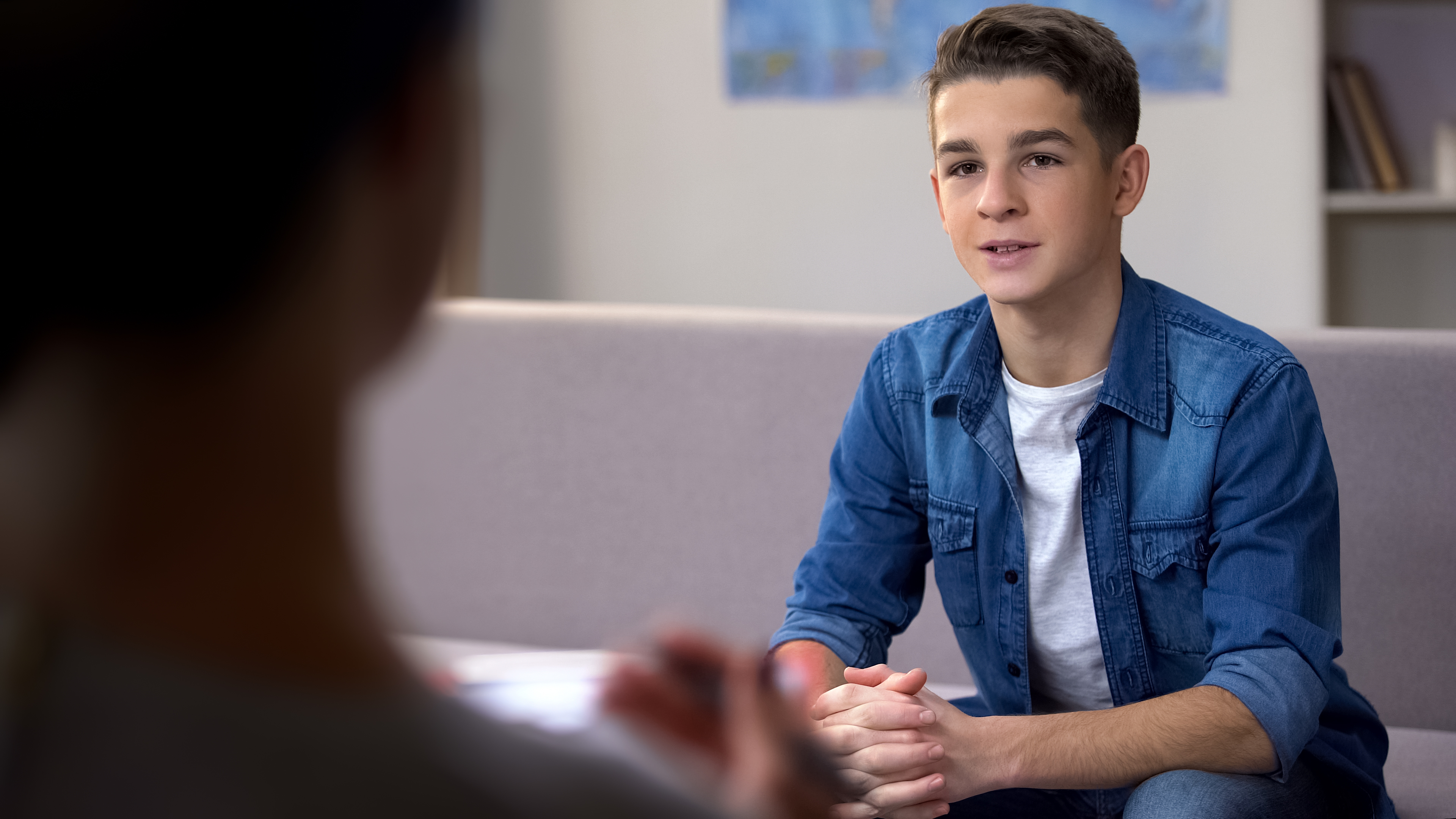 teenage boy in blue short talks to a Youth Talk charity therapist